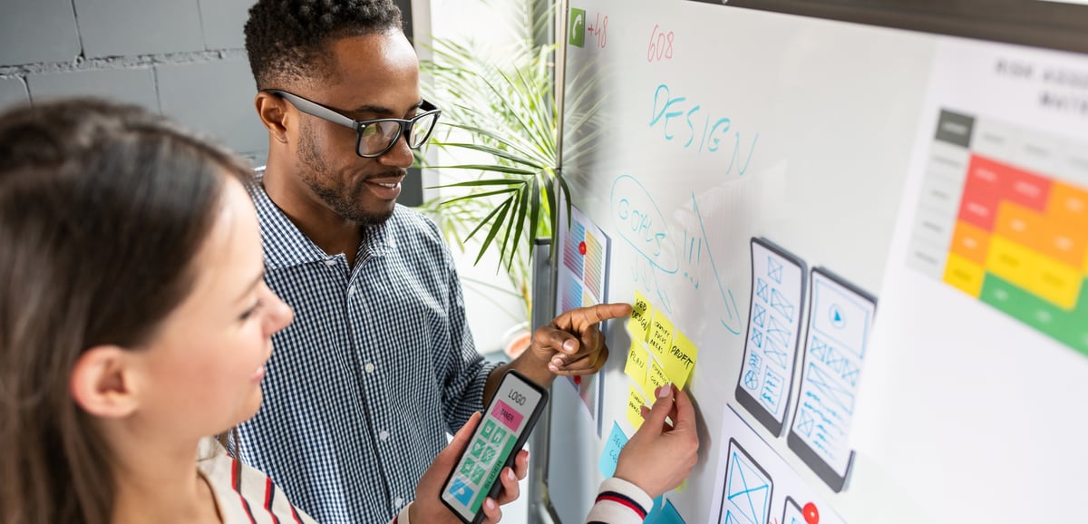 Two people looking at white board email header image